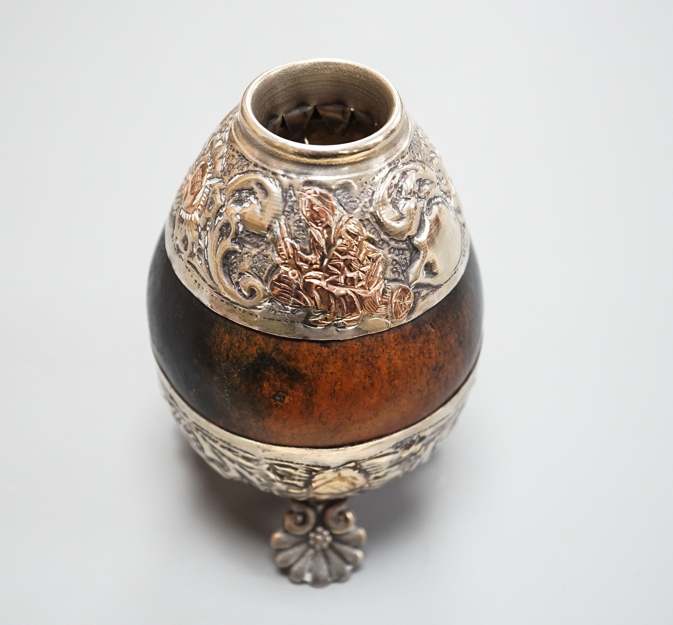 A 20th century maté cup gourd with white and yellow metal repoussé decoration, height height 10cm.